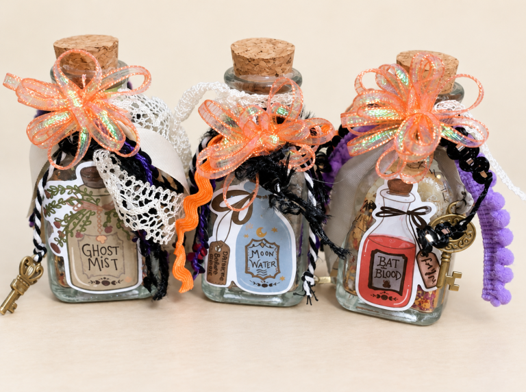 Three decorated Halloween potion bottles with corks, orange bows, lace, ribbons and keys.